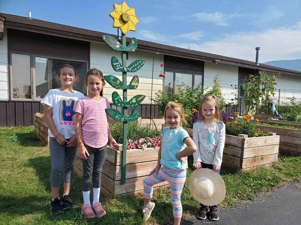 4 students pose by the school gardens