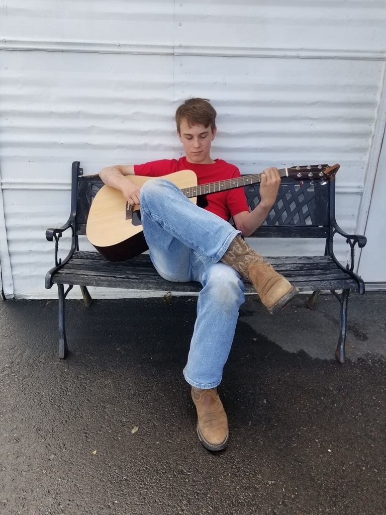young-man-playing-guitar-on-bench