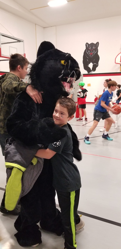 Panther Mascot hugs a boy dressed in black