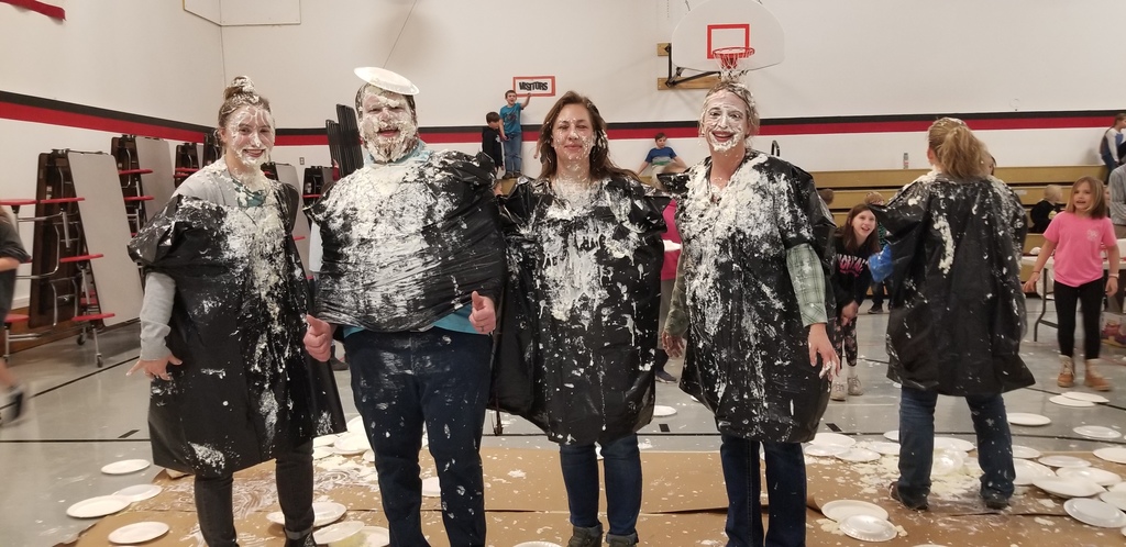 four adults covered in whipped cream