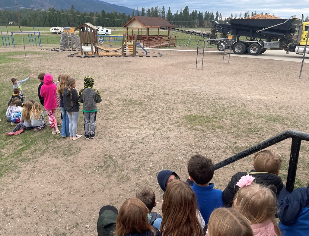 students watching wood chip delivery